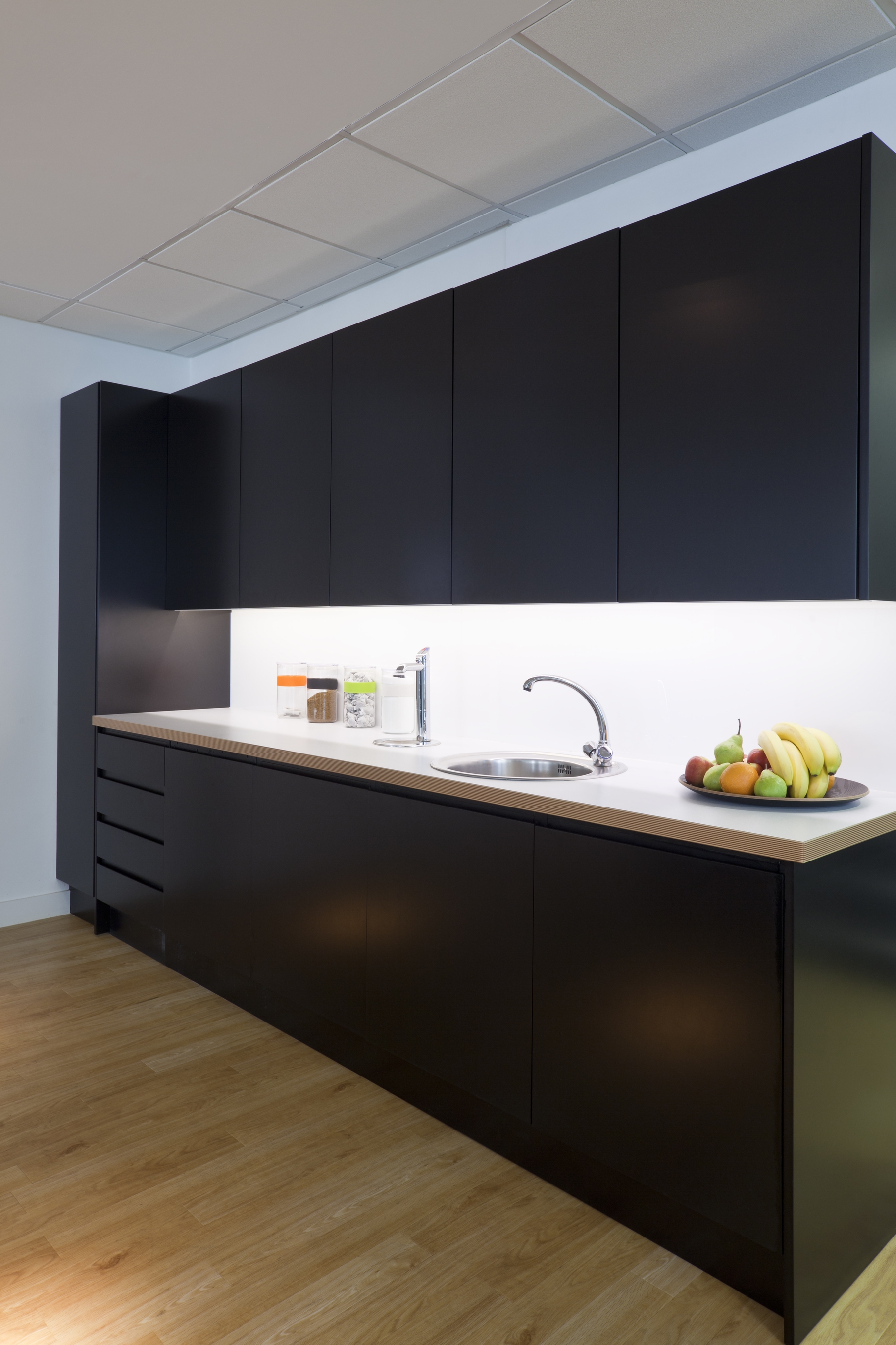Stylish modern office kitchen area with sink and fruit bowl